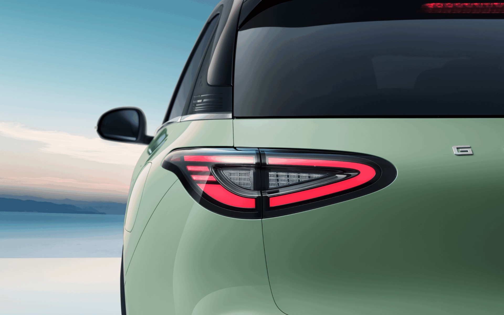 Geely E2 numa rua da cidade, vista traseira em três quartos
